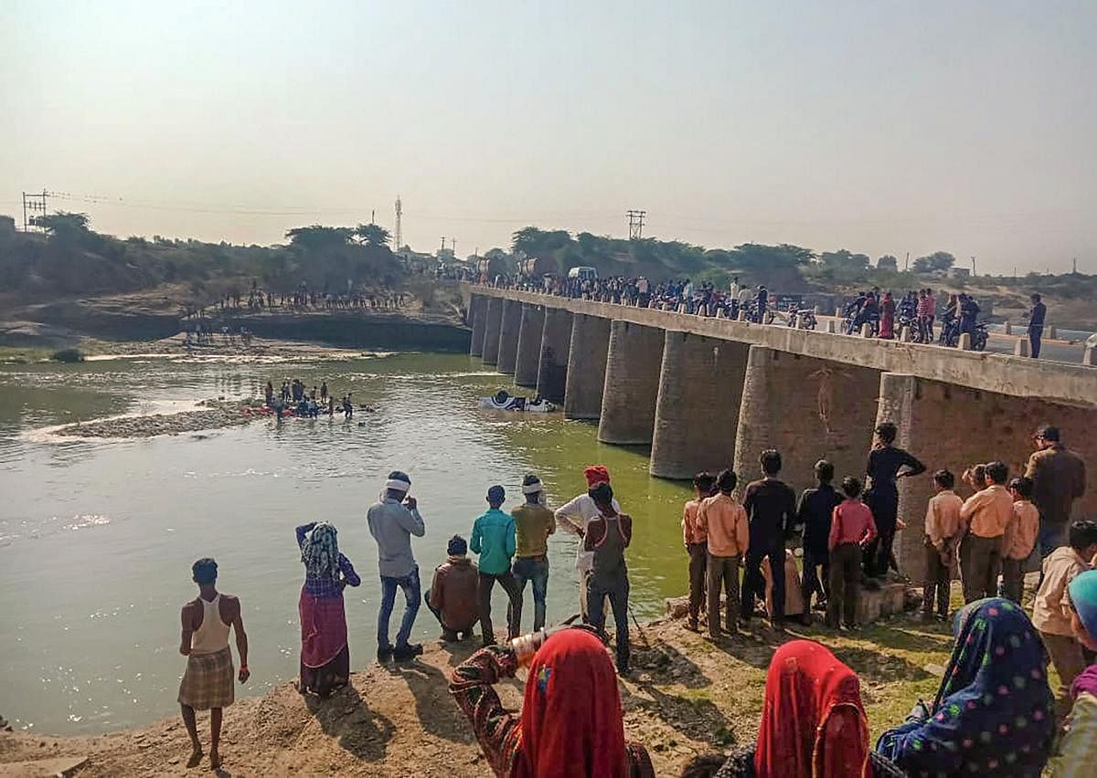 Onlookers gather at the spot where a bus carrying a marriage party fell into a river on Kota-Dausa highway, in Bundi district, Wednesday, Feb. 26, 2020. Credit: PTI Photo