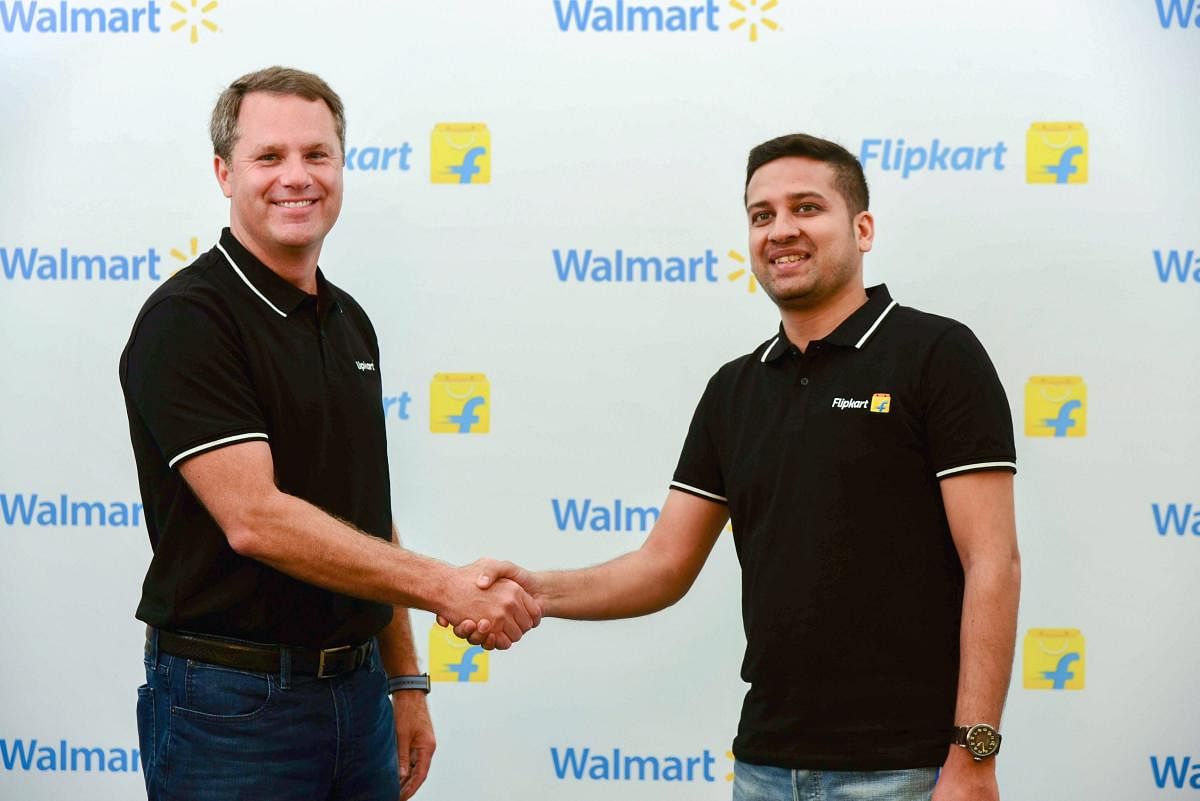 Walmart CEO Doug McMillon with Flipkart Co-Founder and CEO Binny Bansal shake hands in Bengaluru on Wednesday. US retailer Walmart on Wednesday acquired 77 per cent stake in Flipkart for USD 16 billion, the biggest acquisition by a company in India this y