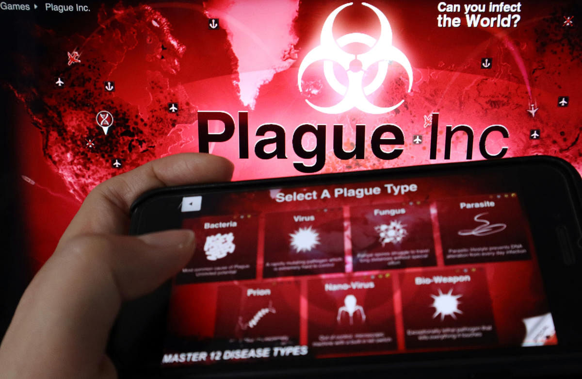 An advertisement for "Plague Inc.", a strategy simulation app that allows users to create and evolve a pathogen to destroy the world, is seen on a mobile phone screen in front of the logo of the game, in this illustration picture taken February 4, 2020. (