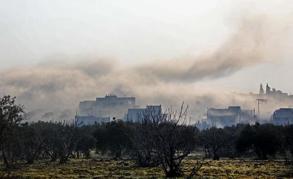 Smoke billows above buildings during an air strike by pro-regime forces on the village of Nayrab, about 14 kilometres southeast of the city of Idlib in northwestern Syria on February 25, 2020. (AFP photo)