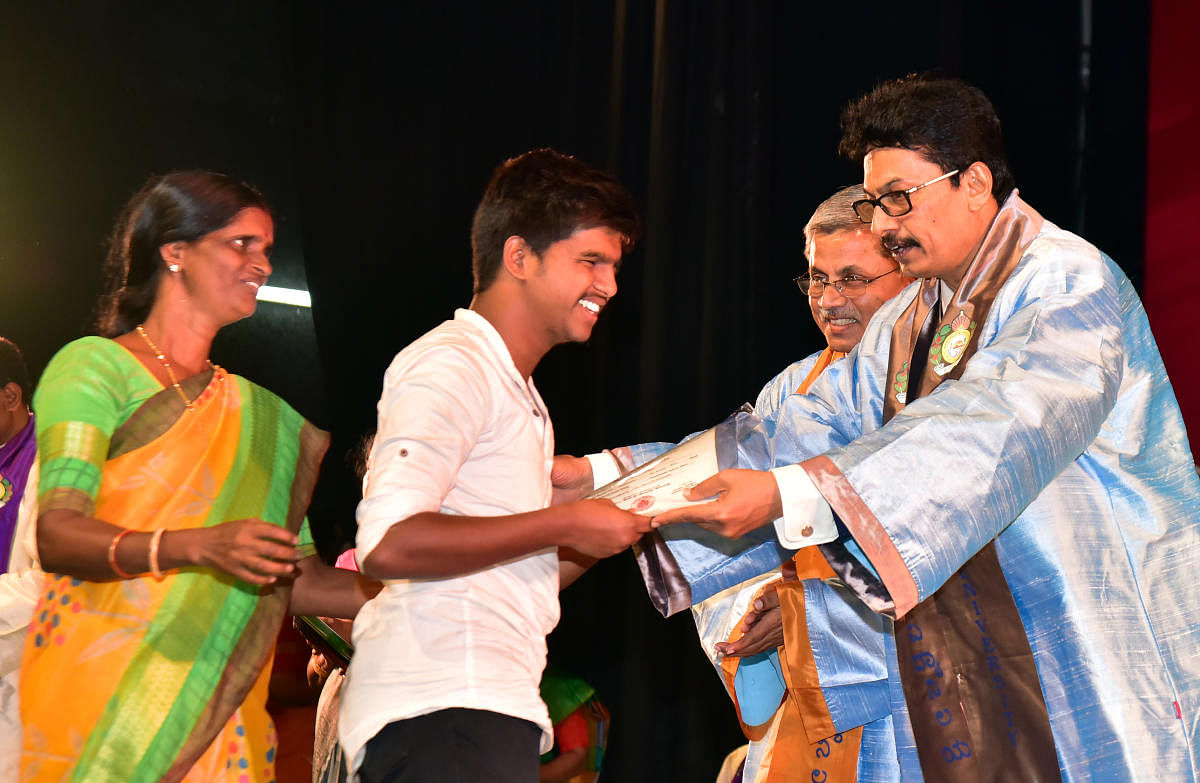 Nithyananda receives the certificate and cash award from Mangalore University (MU) Vice Chancellor Prof P S Yadapadithaya during the 38th Convocation of Mangalore University held at Mangala auditorium on varsity campus on Thursday. DH Photo