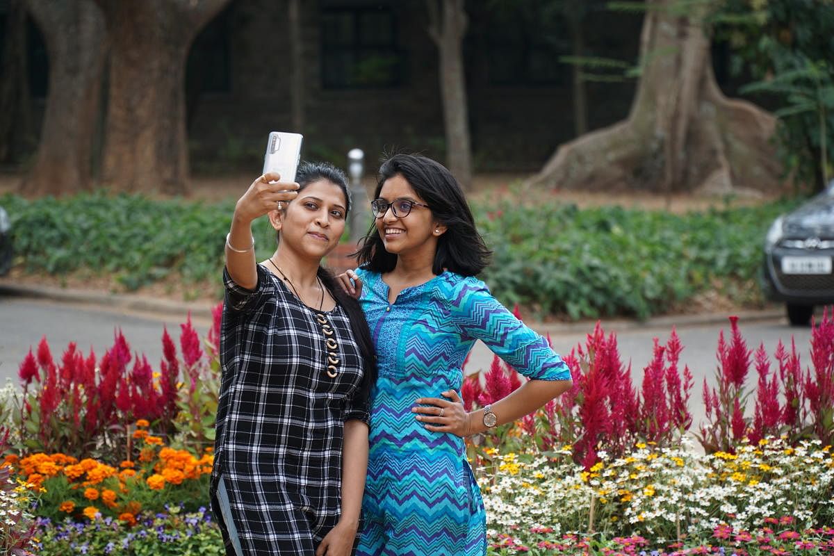 Two students take a selfie in front of floral arrangements laid out for IISc's 2020 "Open Day." Photo taken on Feb 27, 2020.