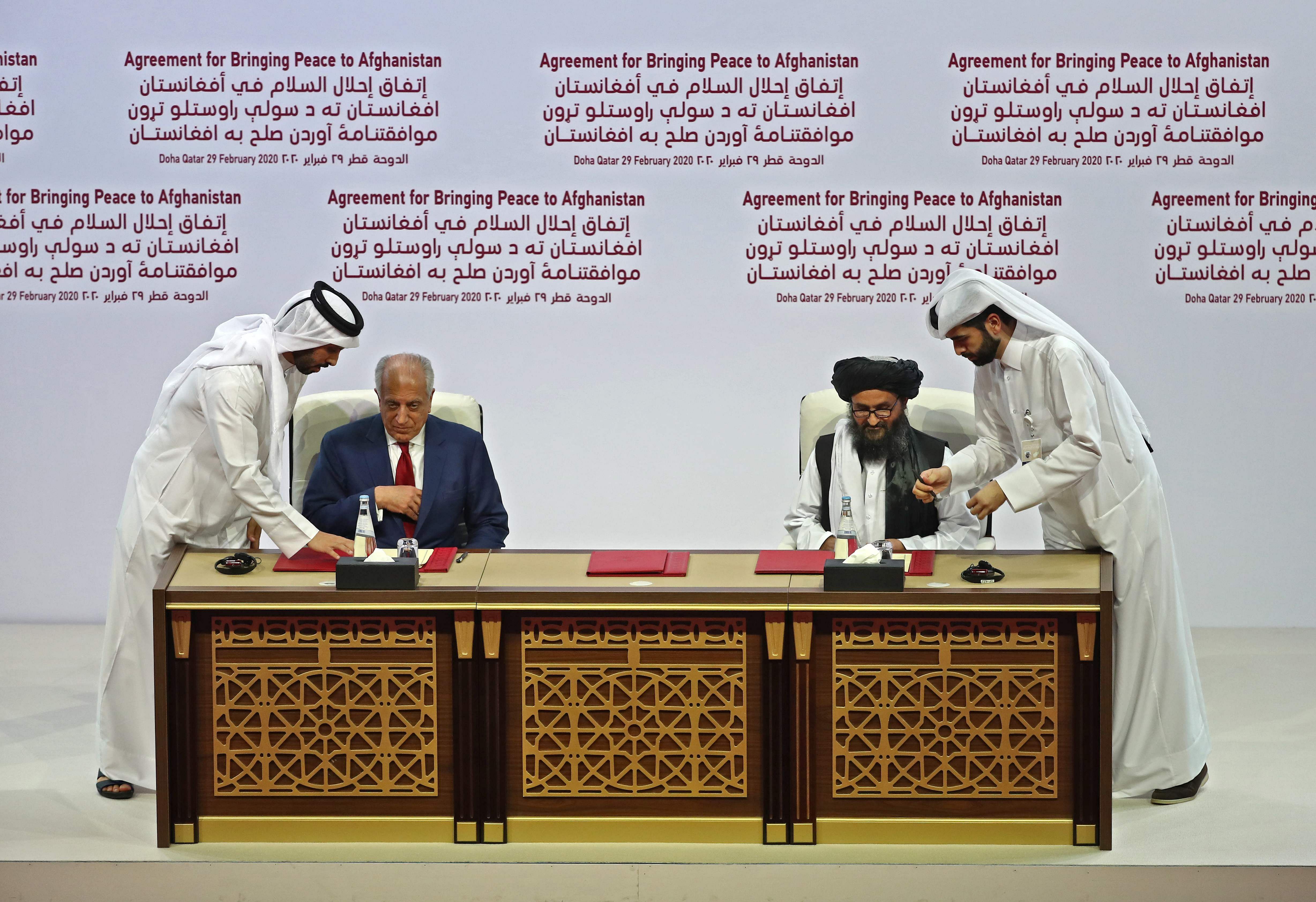 US Special Representative for Afghanistan Reconciliation Zalmay Khalilzad and Taliban co-founder Mullah Abdul Ghani Baradar sign the US-Taliban peace agreement during a ceremony in the Qatari capital Doha on February 29, 2020. (Credit: AFP Photo)