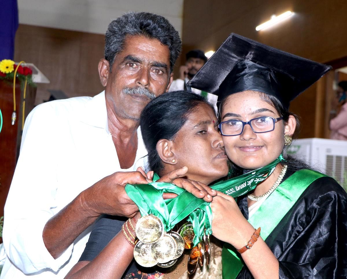 Sushma M K, who bagged a staggering 15 gold medals at 9th convocation of University of Horticultural Sciences, celebrate her feat with her parents Kumar and Chandramati, in Bagalkot on Friday. DH PHOTO