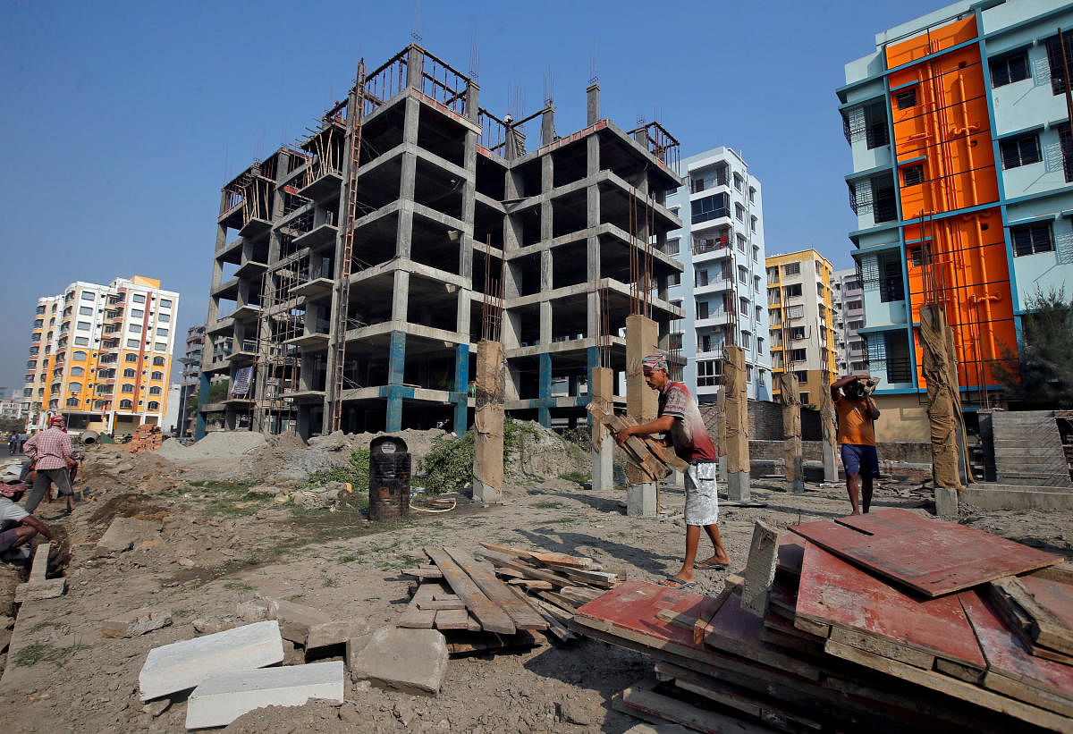 FILE PHOTO: Labourers work at the construction site of residential buildings on the outskirts of Kolkata. REUTERS