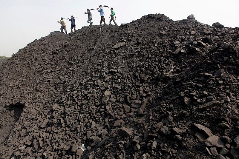Workers walk on a heap of coal at a stockyard of an underground coal mine in the Mahanadi coal fields at Dera, near Talcher town in the eastern Indian state of Orissa. (Reuters Photo)