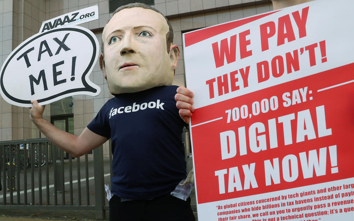An activist wearing a mask depicting Facebook's CEO Mark Zuckerberg demonstrates during the European Union finance ministers meeting, outside the EU headquarters in Brussels, Belgium. (File Photo: REUTERS/Yves Herman)