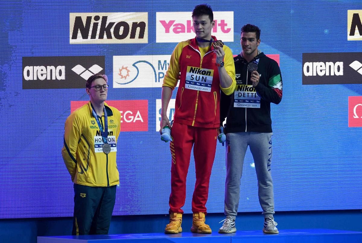 (FILES) In this file photo taken on July 21, 2019 Silver medallist Australia's Mack Horton (L) refuses to stand on the podium with gold medallist China's Sun Yang (C) and bronze medallist Italy's Gabriele Detti after the final of the men's 400m freestyle