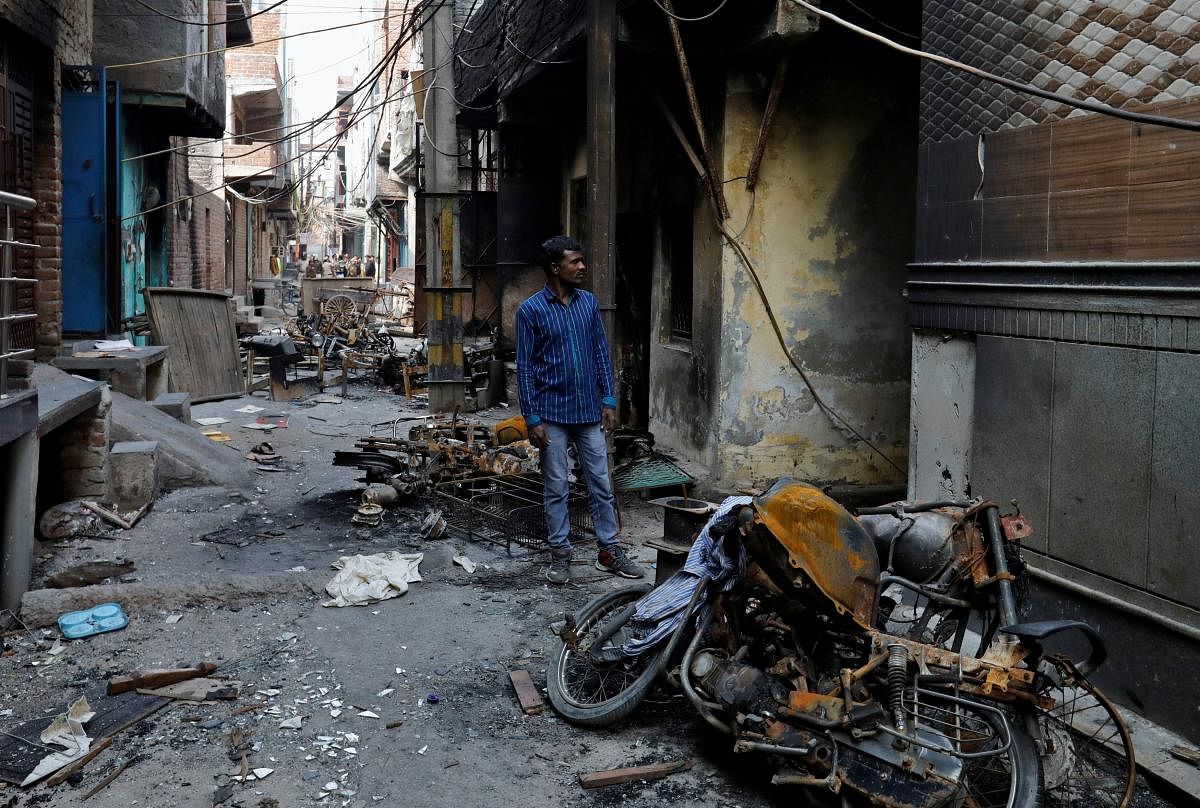 A man looks at burnt out properties owned by Muslims in a riot affected area following clashes between people demonstrating for and against a new citizenship law in New Delhi. Credit: Reuters Photo