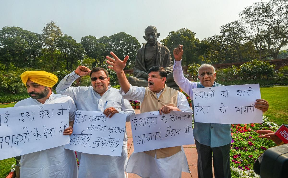 Aam Aadmi Party MPs Sanjay Singh, Bhagwant Mann, N D Gupta and Sushil Gupta raise slogans during a protest over Delhi violence, at Parliament during the ongoing Budget Session, in New Delhi, Monday, March 2, 2020. (PTI Photo)