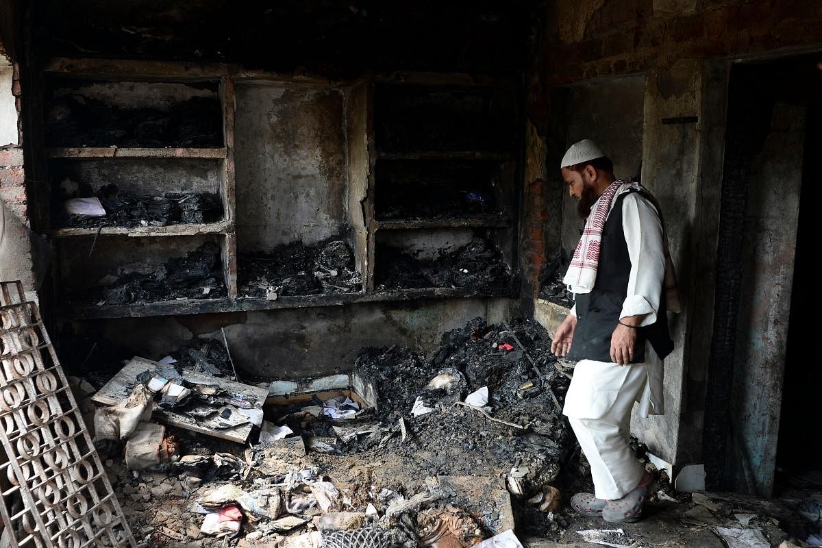 A Muslim man walks inside a burned house in a riot-affected area, in New Delhi (AFP Photo)