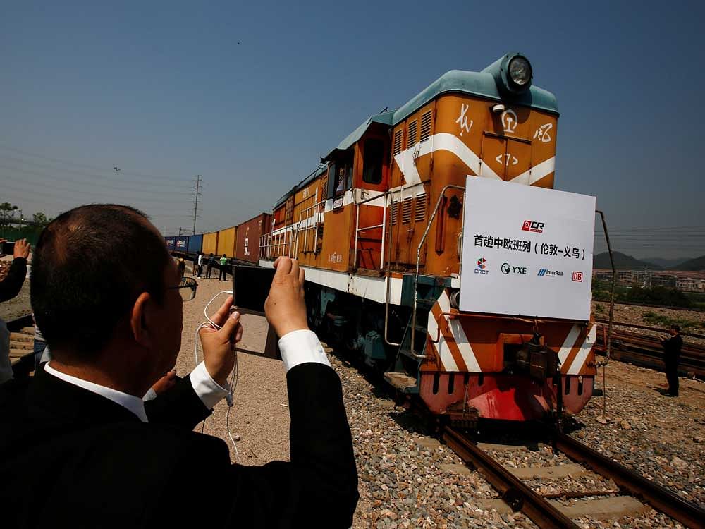 An official takes pictures as a train carrying containers from London arrives at the freight railway station in Yiwu, Zhejiang province, China. Reuters Photo