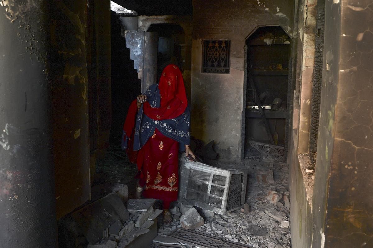 A resident walks inside a damaged building in a riot-affected area after violence broke out in Delhi. (AFP Photo)