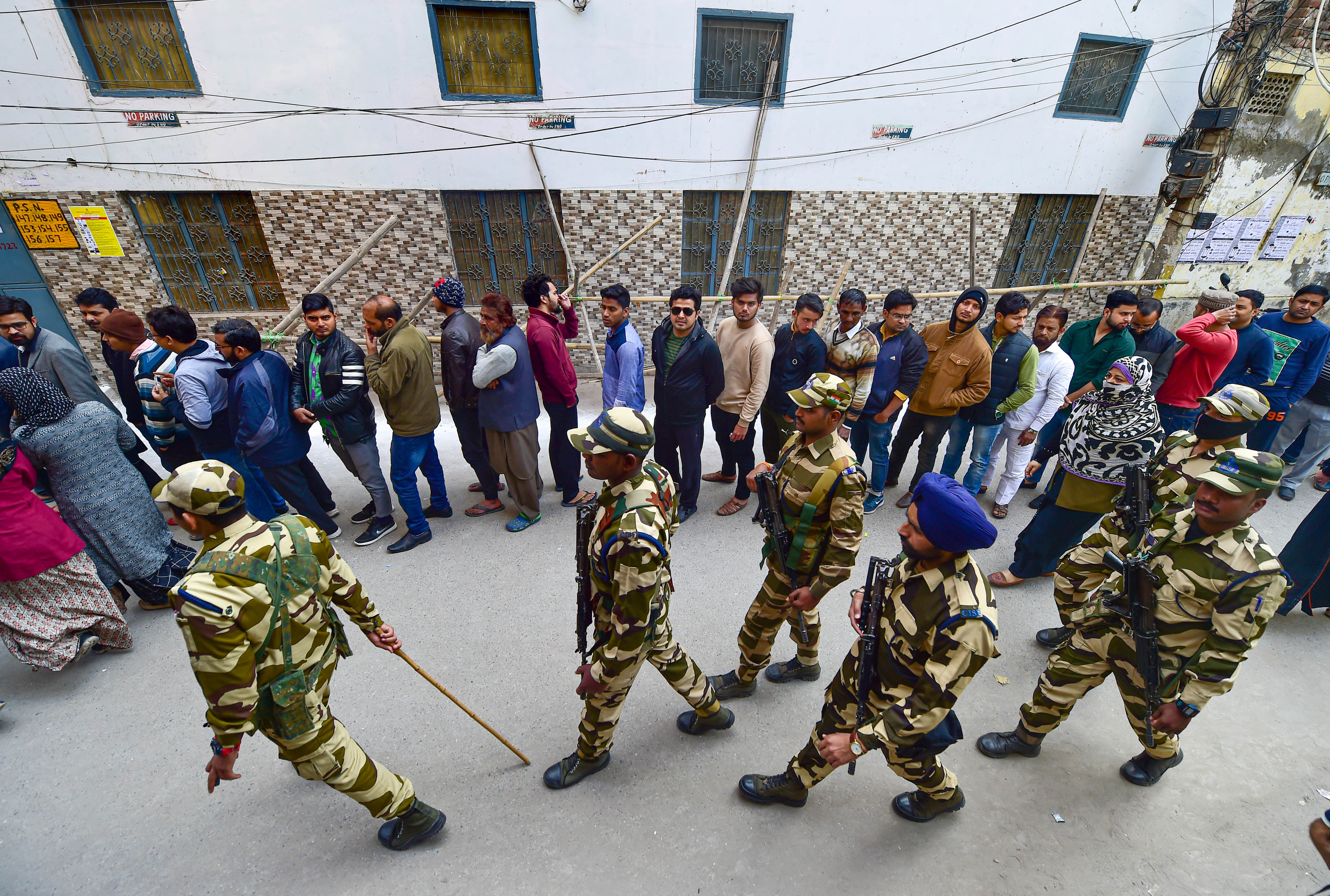Para-military jawans stand guard outside Shaheen Public School polling station in the Shaheen Bagh area. (PTI Photo)