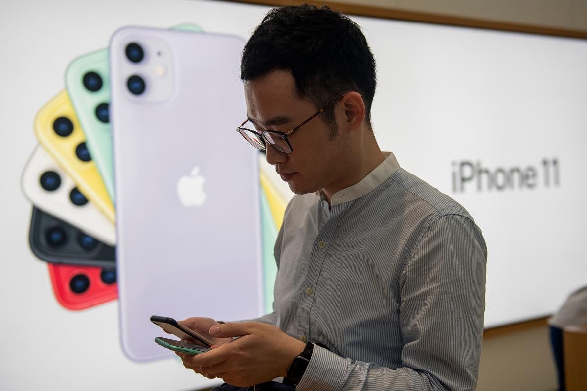 (FILES) In this file photo taken on September 20, 2019 A man tries out the new iPhone 11 smart phone at an Apple store in Hong Kong. - Apple has agreed to pay up to USD 500 million to settle a class-action lawsuit over claims it covertly slowed older iPho