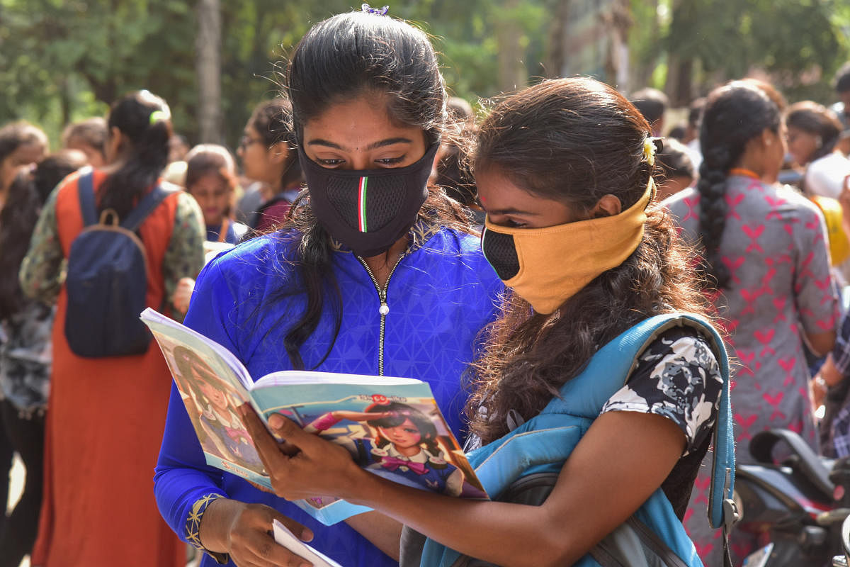Second-year pre-university students wearing masks make last-minute preparation for the exam at a centre in Bengaluru on Wednesday. DH Photo/S K Dinesh