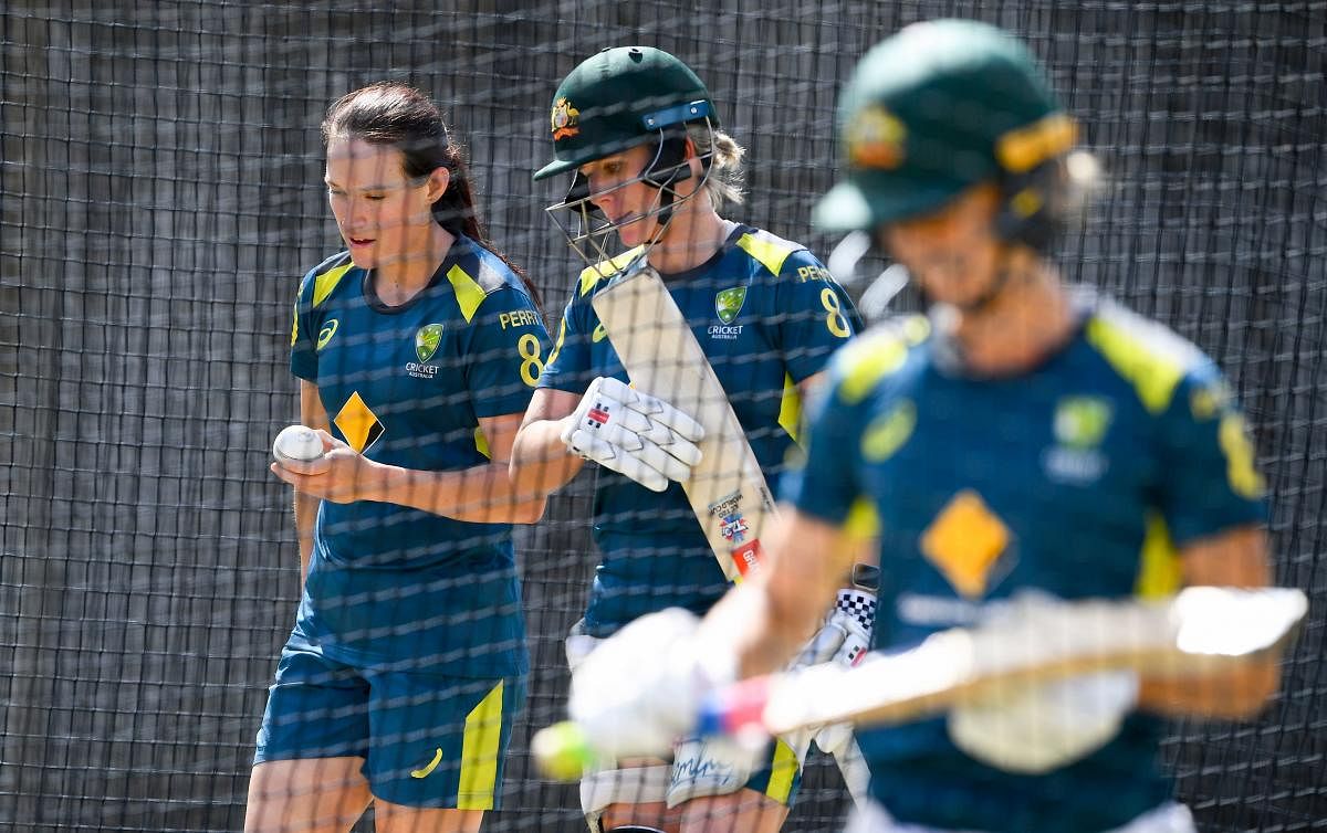 Australia's Megan Schutt (L) and Beth Mooney (C) as they train in the nets ahead of the Twenty20 women's World Cup cricket final, in Melbourne on March 7, 2020. (Photo by William WEST / AFP) 