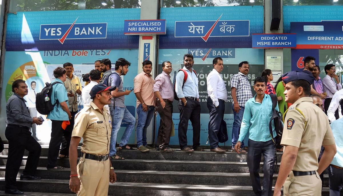  Account holders gather outside Yes Bank to withdraw money, in Thane, Friday, March 6, 2020. The central bank on Thursday imposed a moratorium on the capital-starved Yes Bank, capping withdrawals at Rs 50,000 per account and superseded the board of the private sector lender with immediate effect. (PTI Photo)