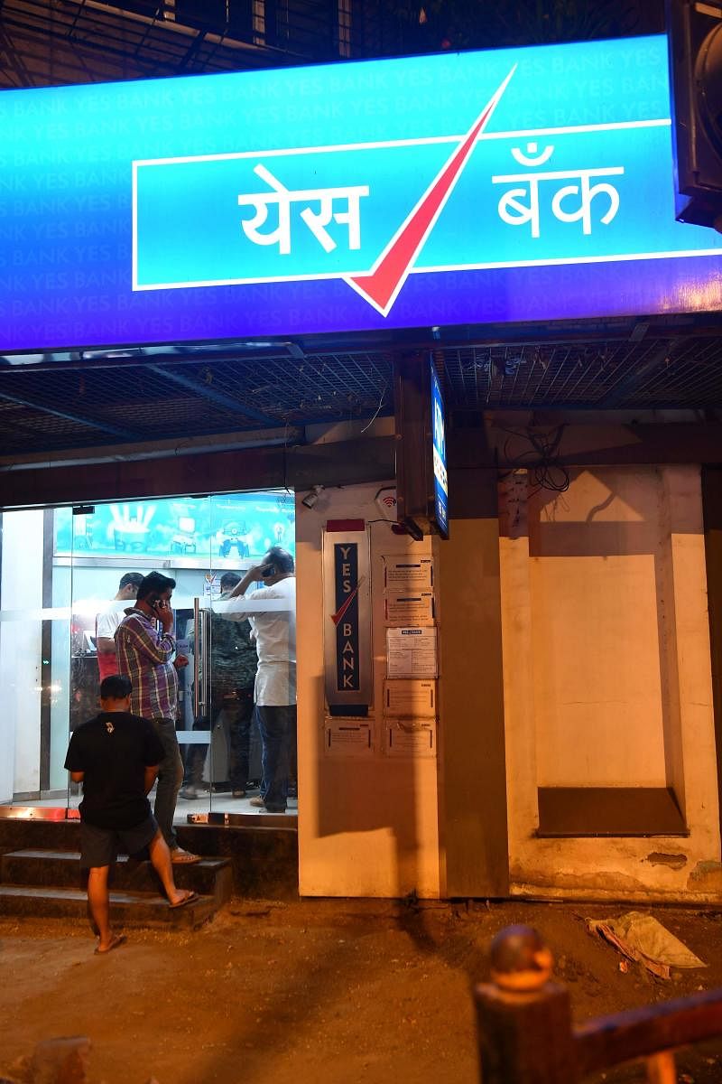 Customers of Yes Bank queue up to withdraw money from their accounts at an  ATM (AFP Photo)
