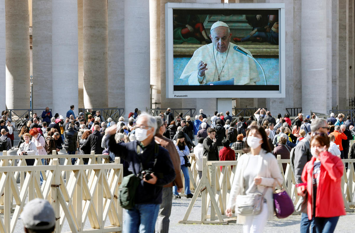 People in face masks walk on St. Peter's Square as Pope Francis delivers his weekly Angelus prayer transmitted via video, due to the coronavirus concerns, in Vatican March 8, 2020. (Reuters Photo)