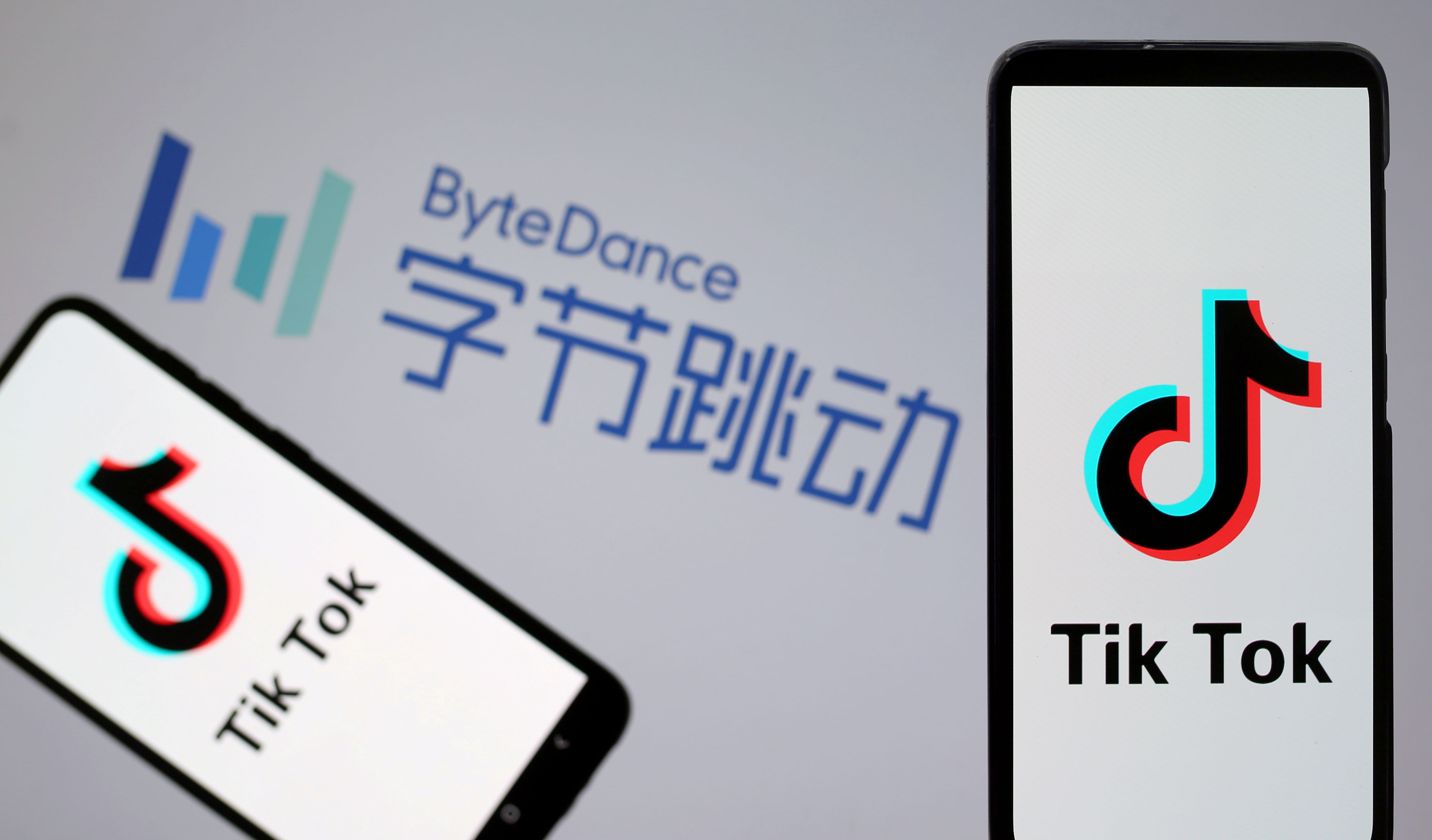 Tik Tok logos are seen on smartphones in front of a displayed ByteDance logo in this illustration. (Reuters Photo)