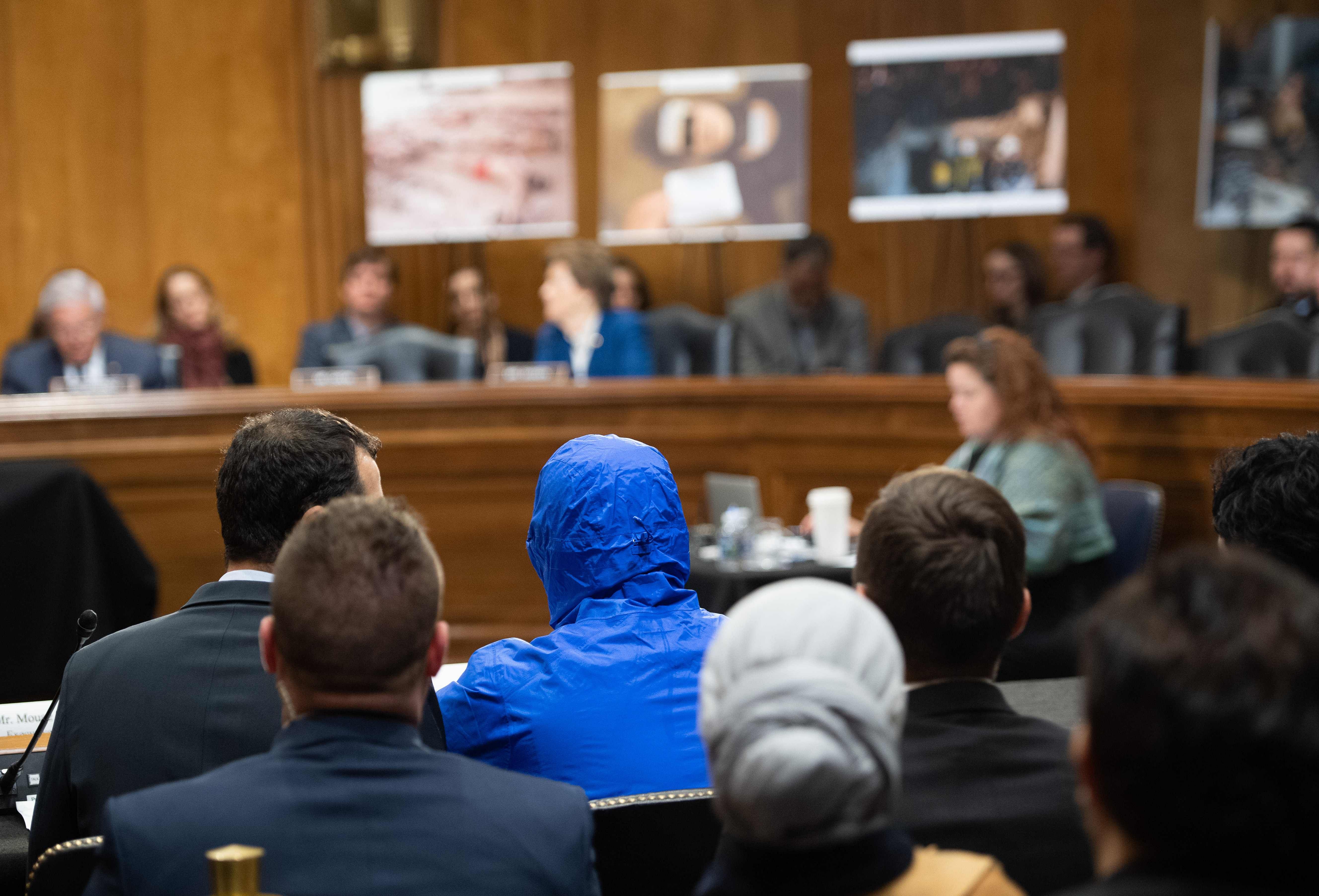 A Syrian military defector using the pseudonym Caesar, while also wearing a hood to protect his identity, testifies about the war in Syria during a Senate Foreign Relations committee hearing on Capitol Hill in Washington. (Credit: AFP)