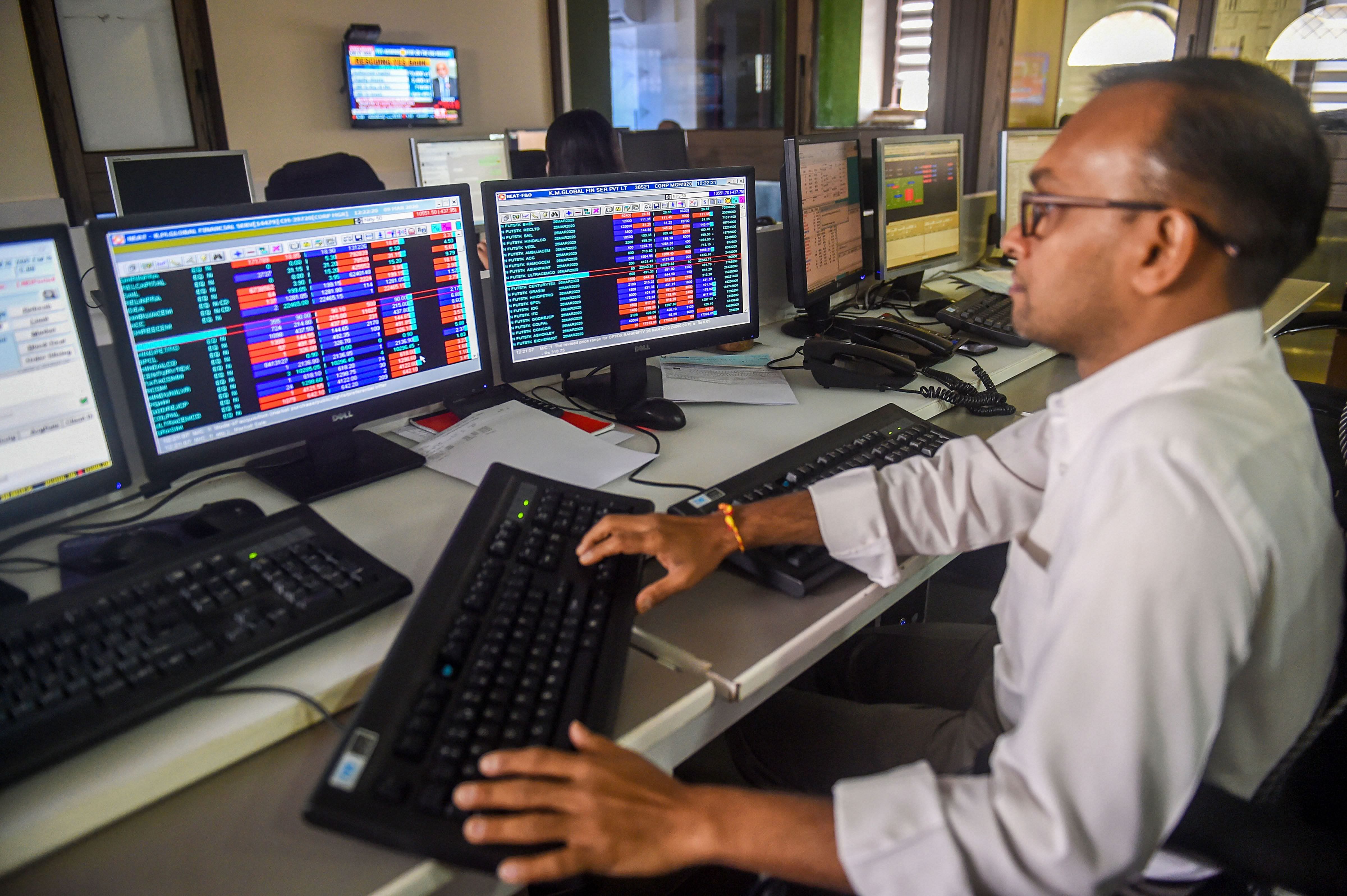 Traders monitor BSE index at a brokerage firm. (Credit: PTI)