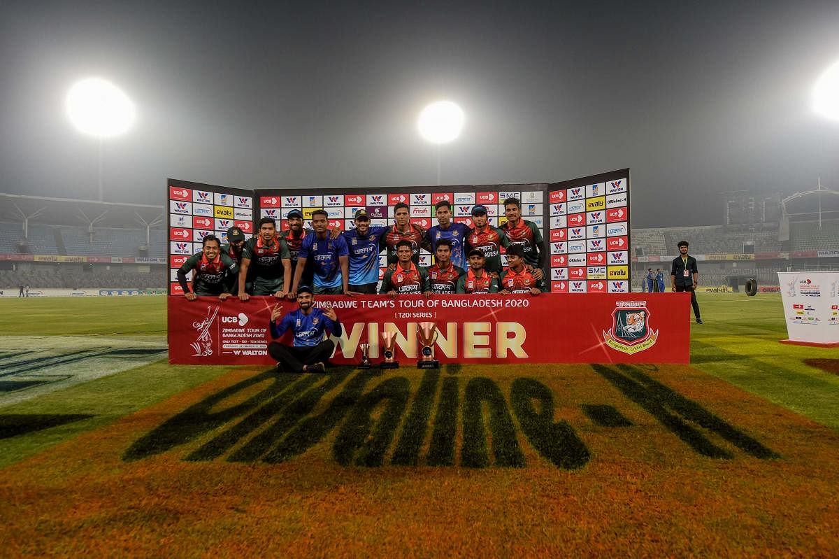 Bangladesh's cricketers pose for photographs with the trophy after winning the second Twenty20 international cricket match of a two-match series between Bangladesh and Zimbabwe (AFP Photo)