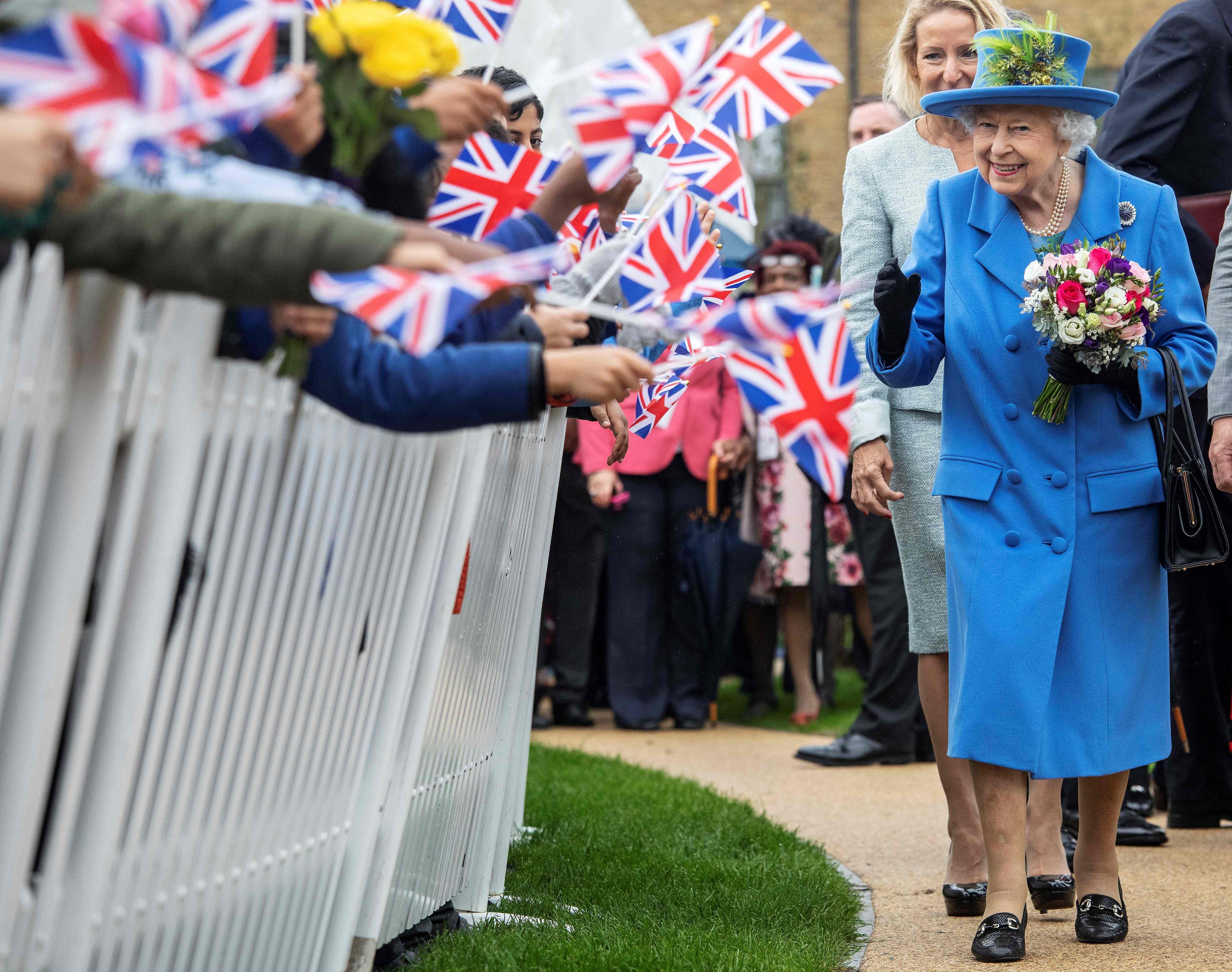 Britain's Queen Elizabeth II reacts as she visits the Haig Housing Trust in Morden, southwest London. (Credit: AFP)