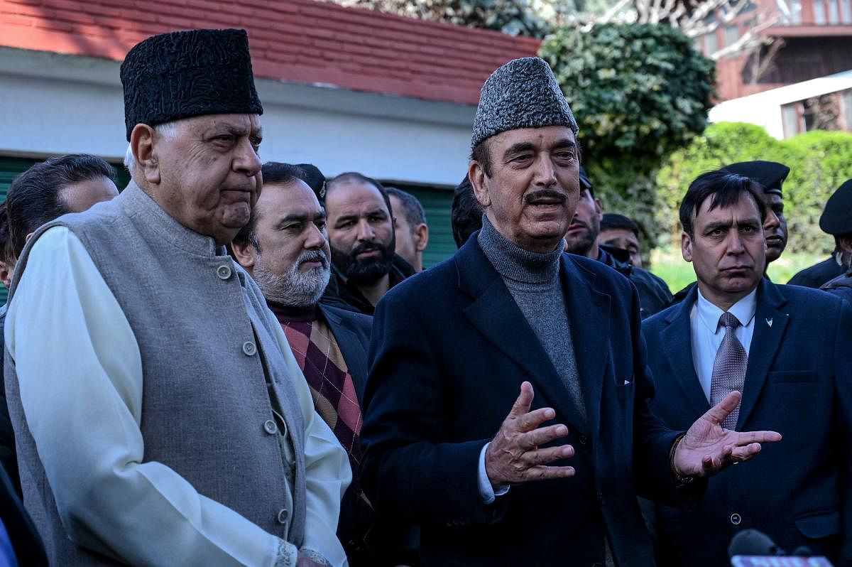 Former Jammu and Kashmir chief minister Farooq Abdullah (L) and senior National Congress leader of opposition in Rajya Sahba (Council of States) Ghulam Nabi Azad (C) speak to media representatives outside Abdullah's residence, after his release, in Srianagar on March 14, 2020. (Photo by Tauseef MUSTAFA / AFP)