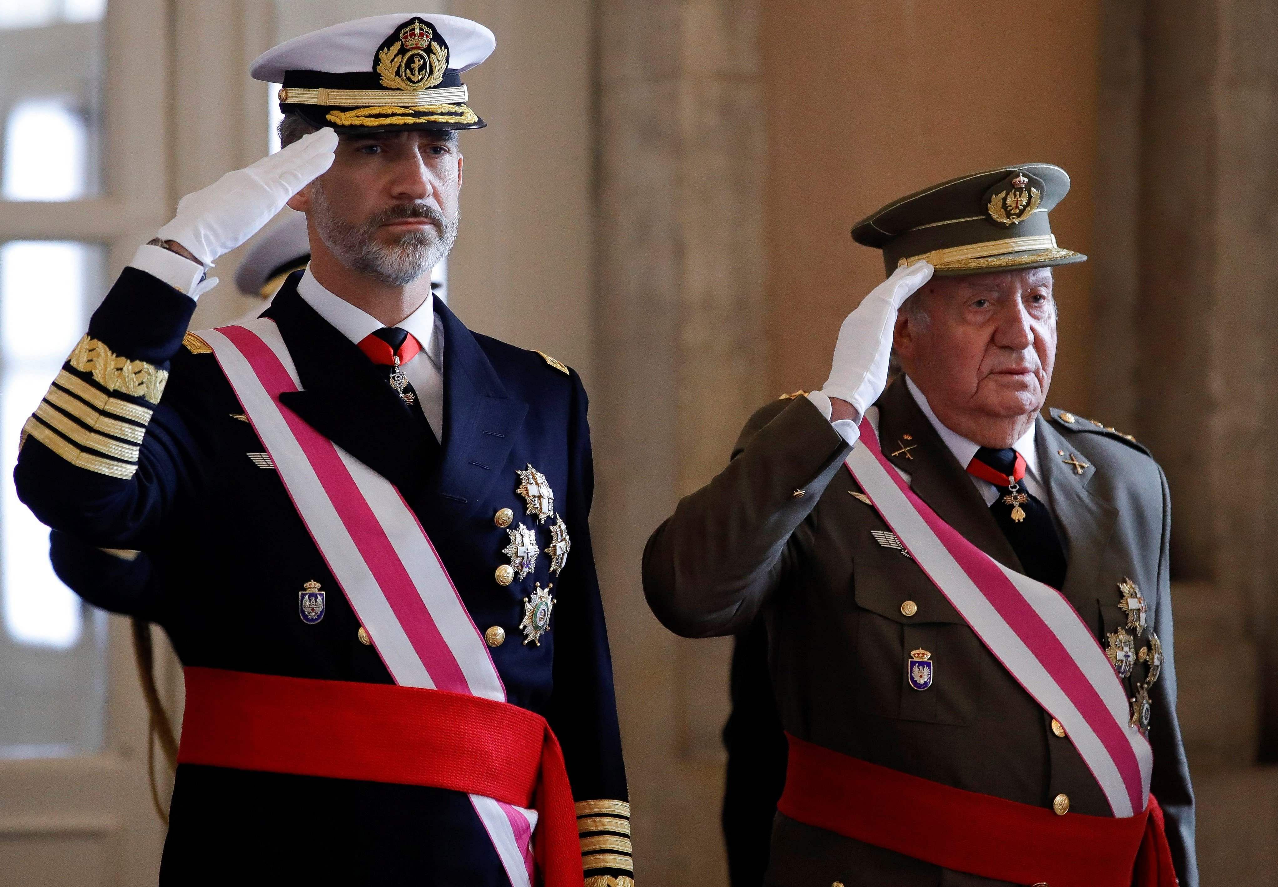 Spain's King Felipe VI (L) and his father King Emeritus Juan Carlos I salute. (Credit: AFP)
