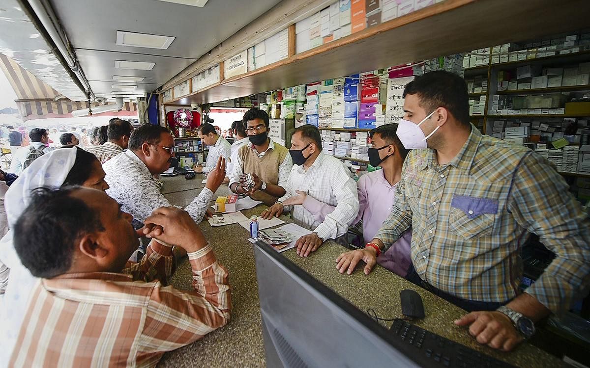  Salesmen at a chemist shop wear protective masks, in wake of the deadly novel coronavirus, outside Safdarjung Hospital, in New Delhi. (PTI Photo)