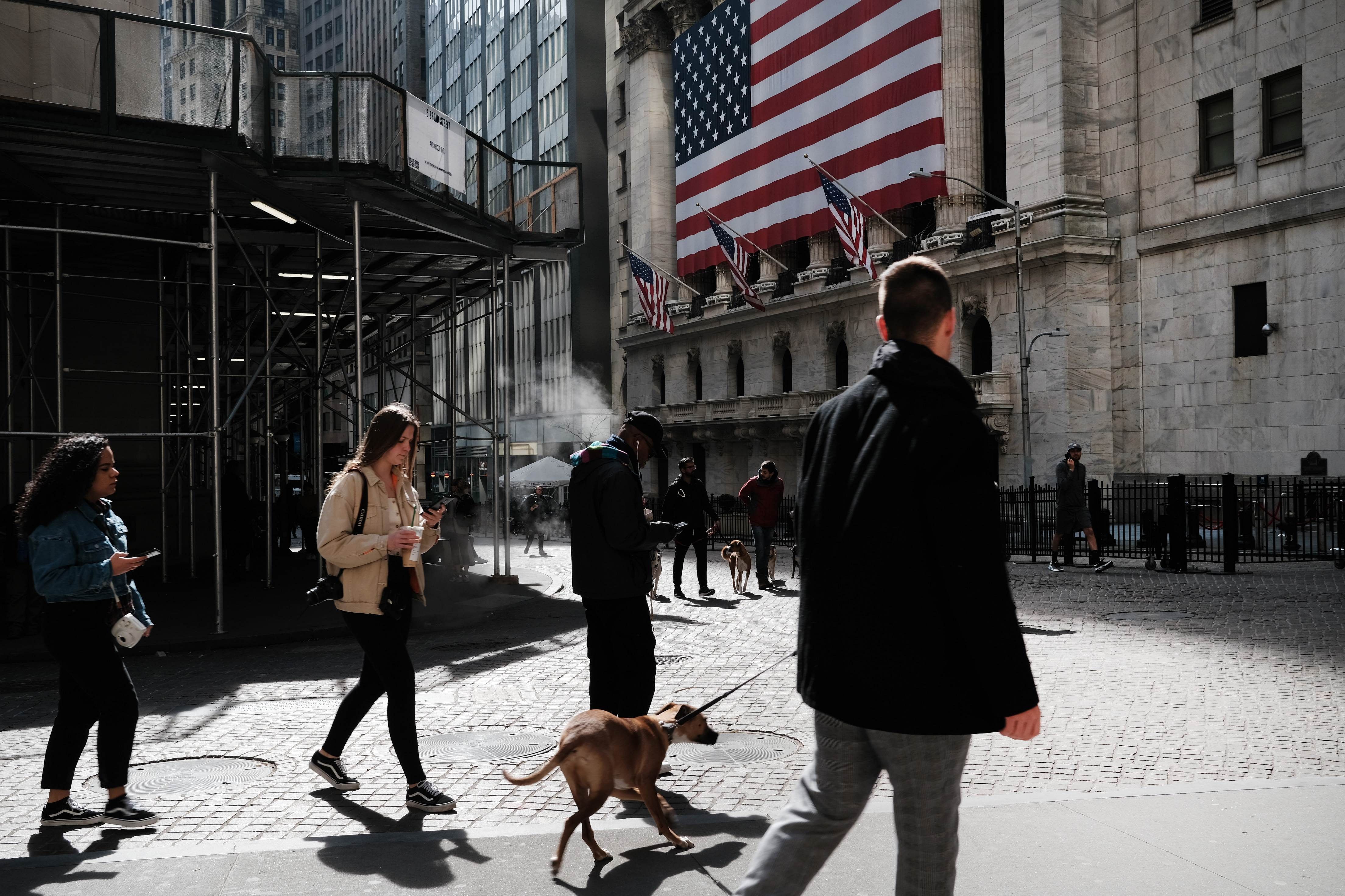 People walk through the Financial District in New York City. (Credit: AFP)