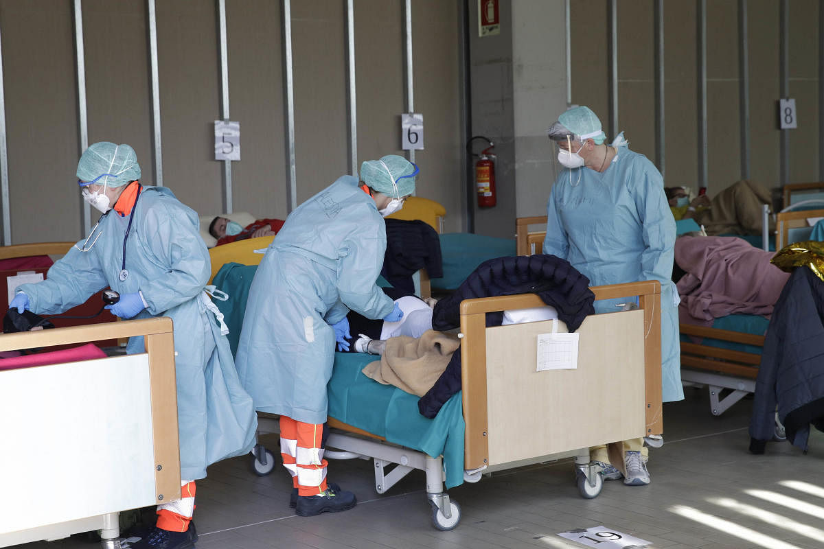 A patient is tended by medical staff at one of the emergency structures that were set up to ease procedures at the Brescia hospital, Italy(AP/PTI Photo)