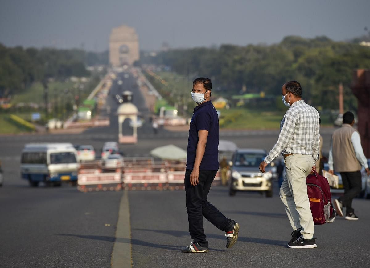 People wearing masks in the wake of coronavirus pandemic cross Raisina Hill road in New Delhi, Thursday, March 19, 2020. (PTI Photo)