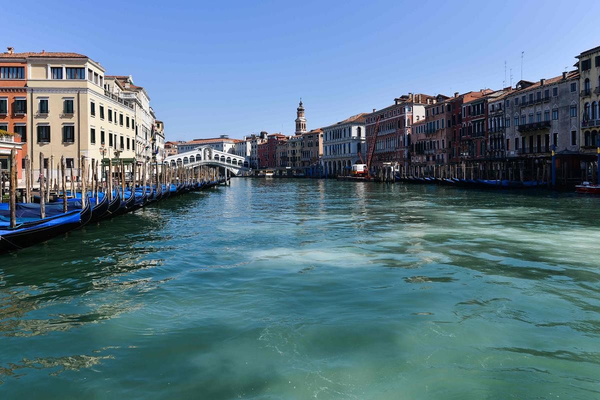 A general view shows clear waters of the Grand Canal near the Rialto Bridge in Venice as a result of the stoppage of motorboat traffic, following the country's lockdown for the new coronavirus crisis. (Photo by ANDREA PATTARO / AFP)