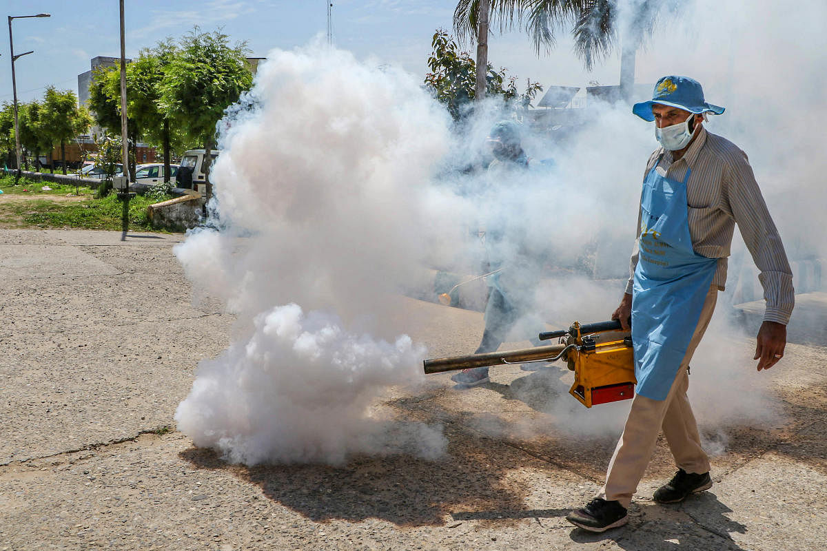 A municipal corporation health worker sprays disinfectant to contain the spread of coronavirus, in Jammu, Monday, March 23, 2020. (PTI Photo)
