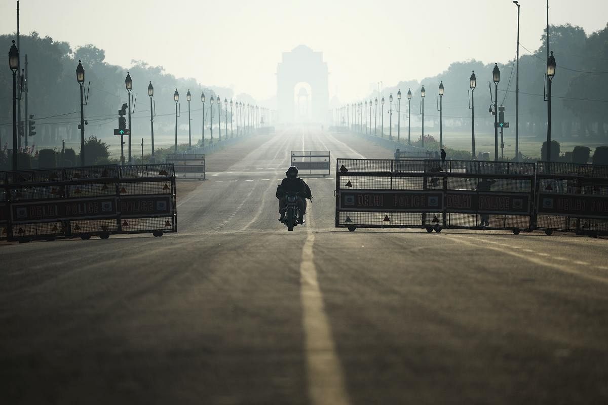 A motorist rides through deserted Rajpath road during a one-day Janata (civil) curfew imposed as a preventive measure against the COVID-19 coronavirus, in New Delhi on March 22, 2020. Credit: PTI Photo