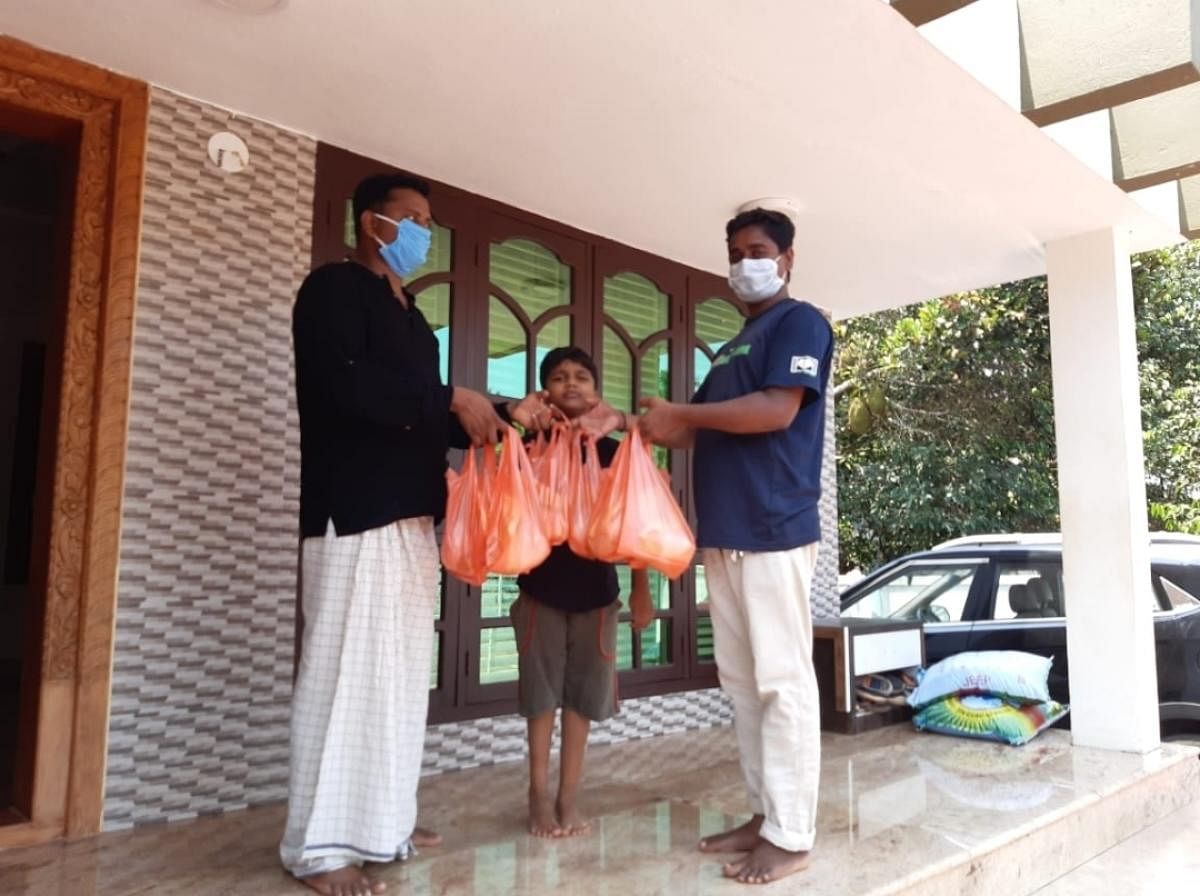 Konaje Gram Panchayat President Nazar Shah hands over food packets to the needy.