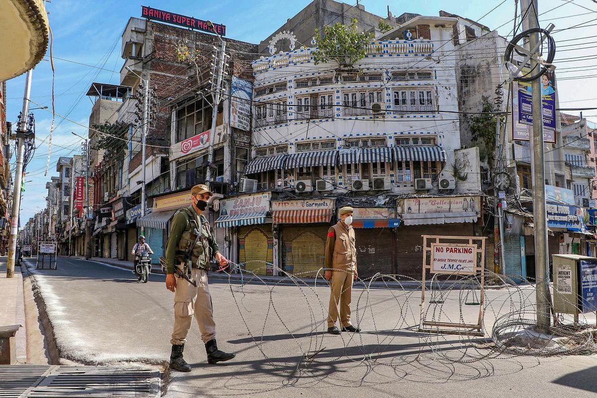 Security personnel keep a watch on a closed street during the lockdown in the wake of coronavirus outbreak, in Jammu. PTI