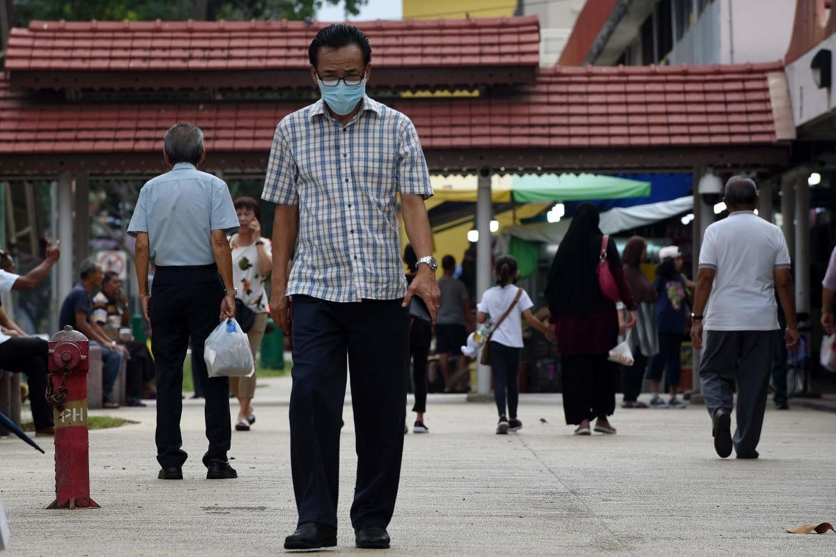 A man wearing a face mask as a preventive measure against the coronavirus, walks around his neighbourhood in Singapore. AFP