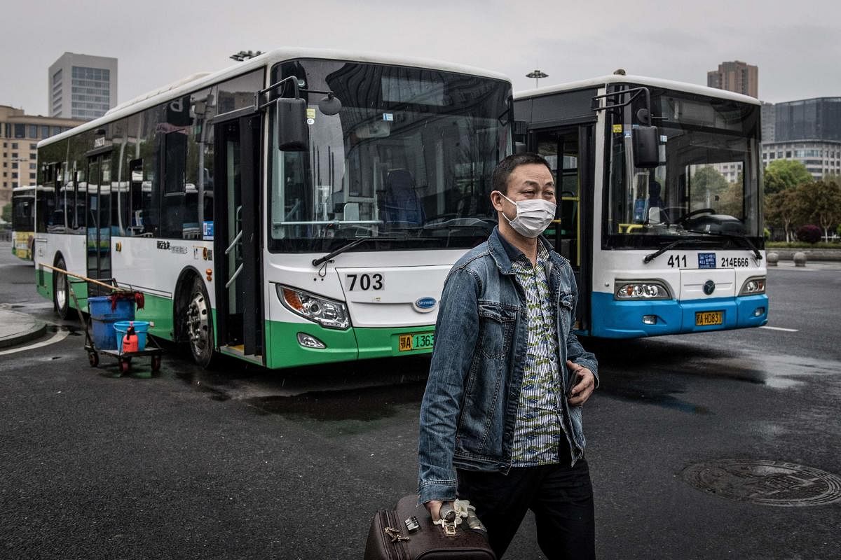 A man gets out of a bus in Wuhan in China's central Hubei province on March 25, 2020, after the public transportation partly resumed in the city. Credit: AFP Photo