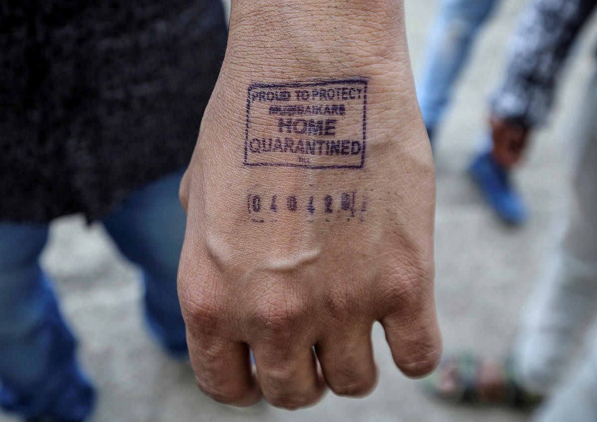 A man shows his hand which was stamped by airport authorities as he was advised for home quarantine after he arrived from overseas, amid coronavirus disease fears, in Mumbai. Credit: Reuters File Photo