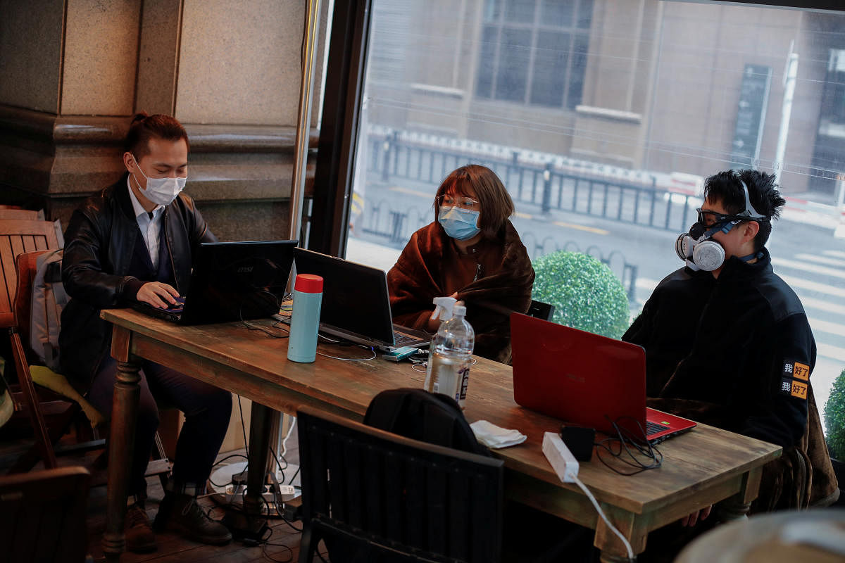 People wear protective masks as they work in a cafe, following an outbreak of the coronavirus disease (COVID-19) in Beijing. (Reuters Photo)