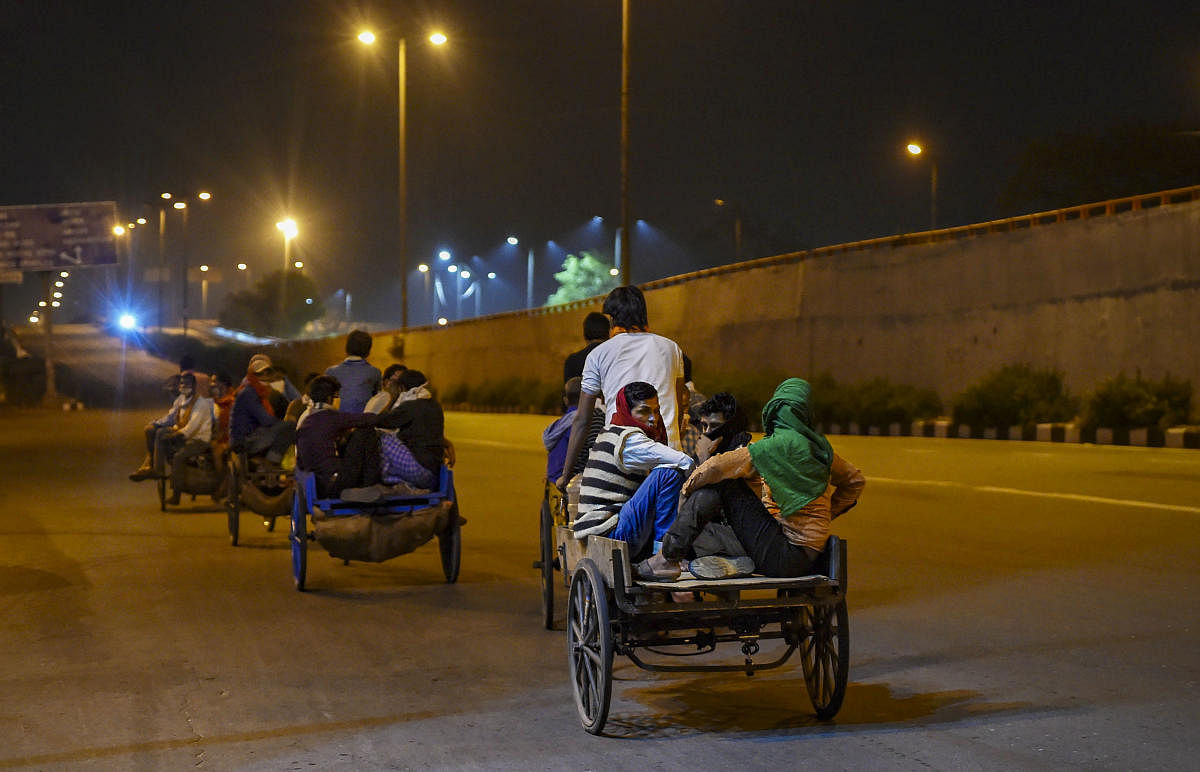 Migrant workers return to their native places amid the nationwide complete lockdown, on the Gandhi Nagar in East Delhi , Thursday, March 26, 2020. The migrants, reportedly, started to foot it to their villages in Uttar Pradesh after they were left with no other option following the announcement of a 21-day lockdown across the country to contain the Covid-19, caused by the novel coronavirus. (PTI Photo)