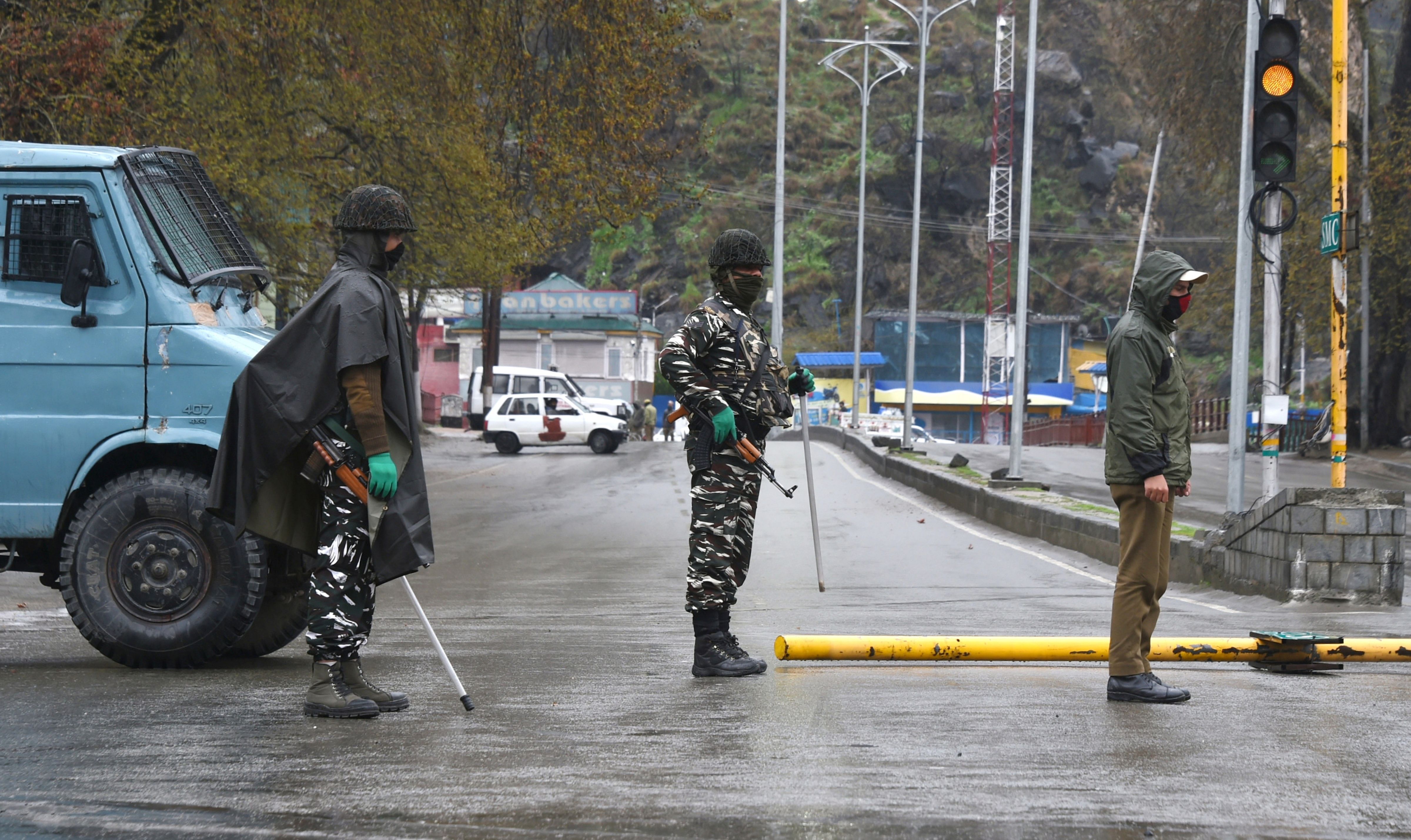 Security personnel stand guard on a road during 3rd day of the 21-day nationwide lockdown to fight the coronavirus pandemic, in Srinagar. (Credit: PTI)