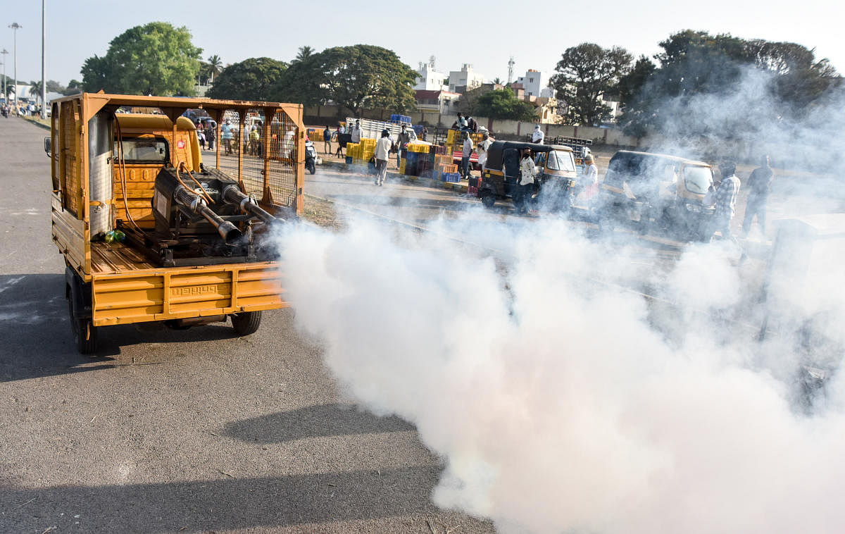 Mysuru City Corporation personnel carry out fogging on the Dasara Exhibition Grounds in Mysuru, where the MG Road vegetable market vendors have been shifted, on Saturday. dh photo