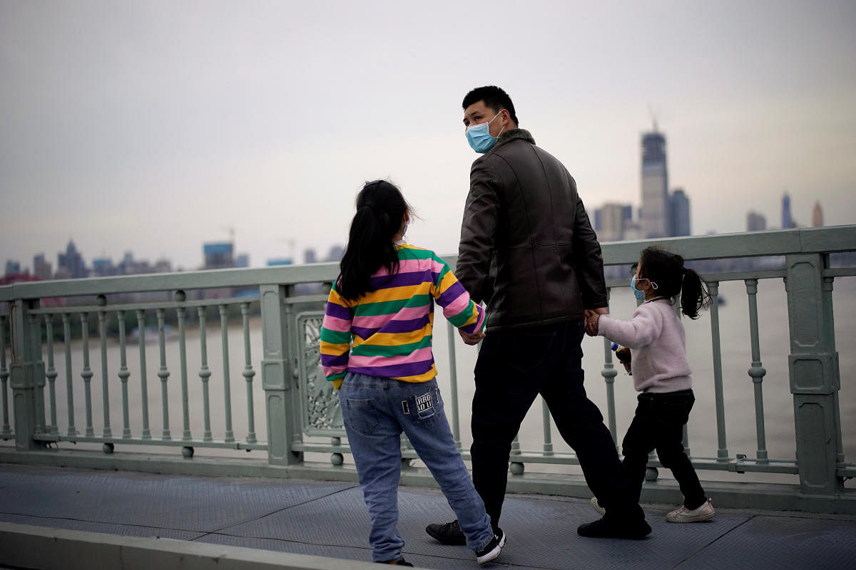 People wearing face masks walk on a bridge in Wuhan, Hubei province, the epicenter of China's coronavirus disease (COVID-19) outbreak (Reuters Photo)