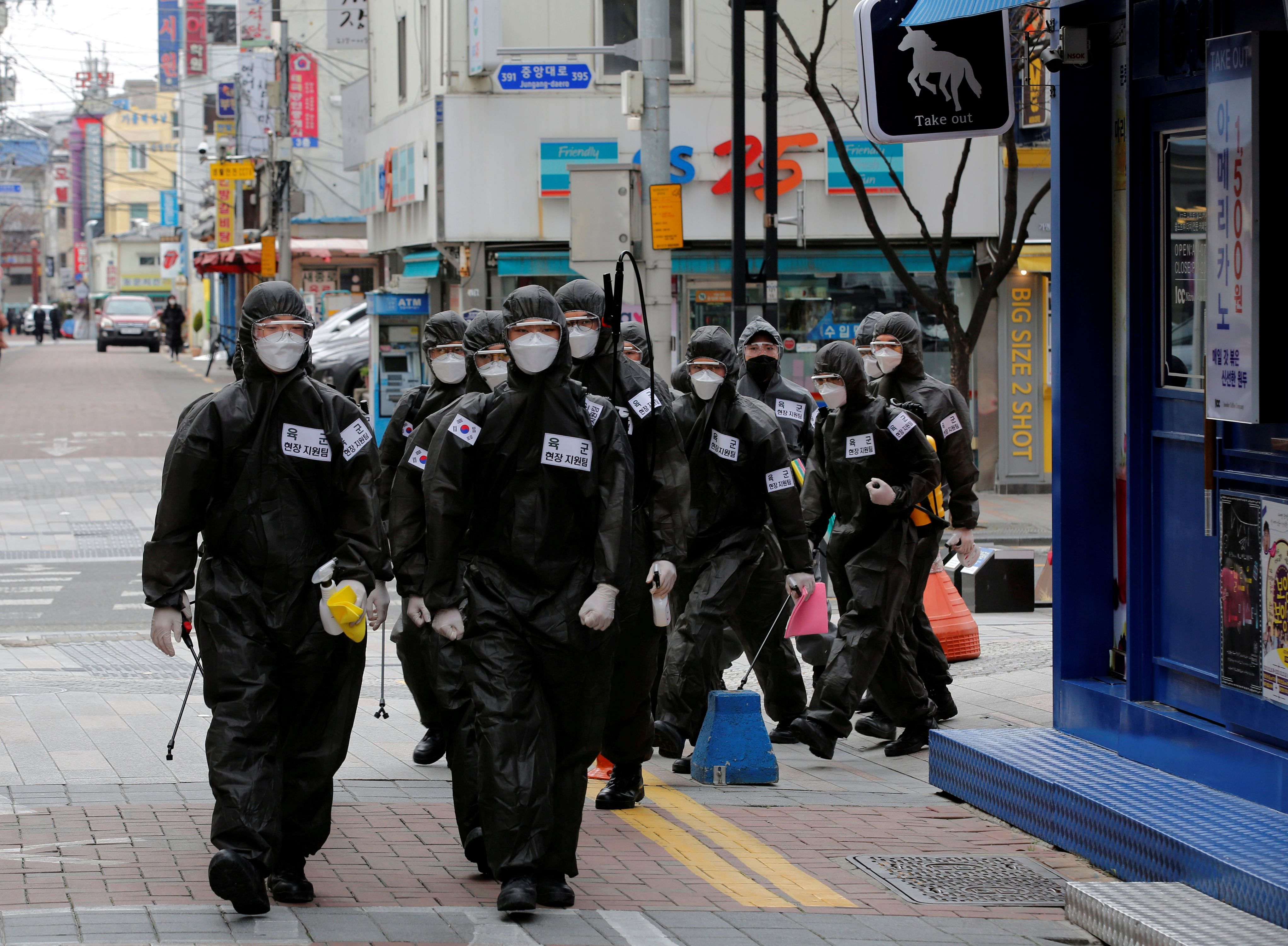 South Korean soldiers in protective gear make their way while they disinfect buildings downtown, following the rise in confirmed cases of coronavirus disease (COVID-19) in Daegu, South Korea, (Credit: Reuters)