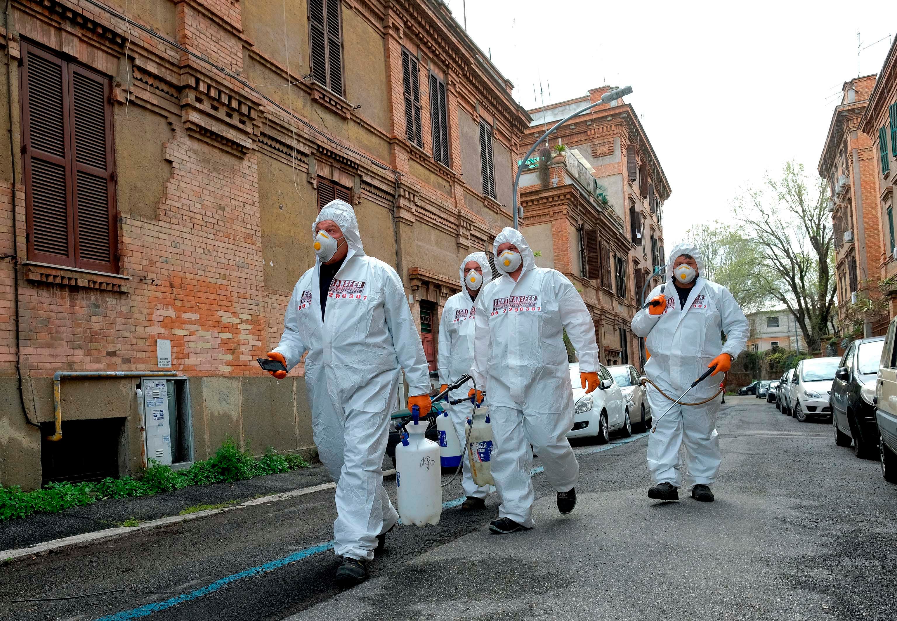 Rome: Workers wearing protective outfits sanitize a neighbourhood. (Credit: AP)